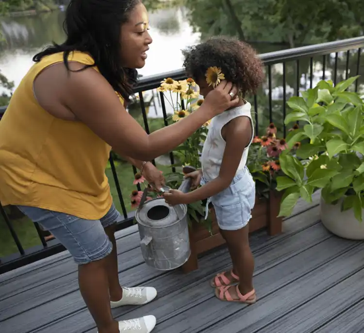 Image Parent And Child Watering Flowers On Composite Deck 2X