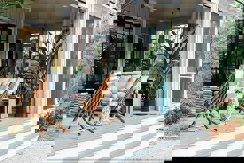 Patio with wooden chairs plants and grey box stairs