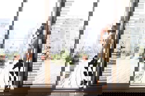 Person Enjoying Coffee On Minimalist Styled Patio Highlighting Simplicity And Coziness